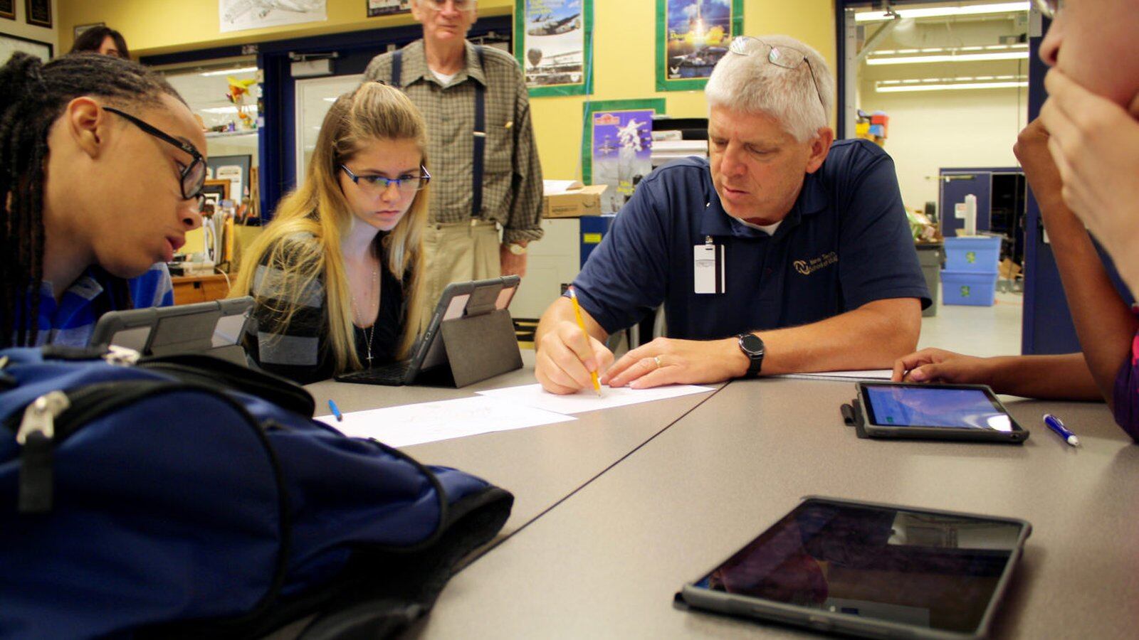 Students in Decatur Township work on physics problems with their teacher.