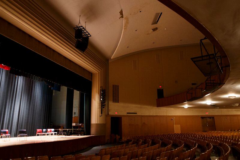 A high school auditorium with a view of the stage and seat rows.