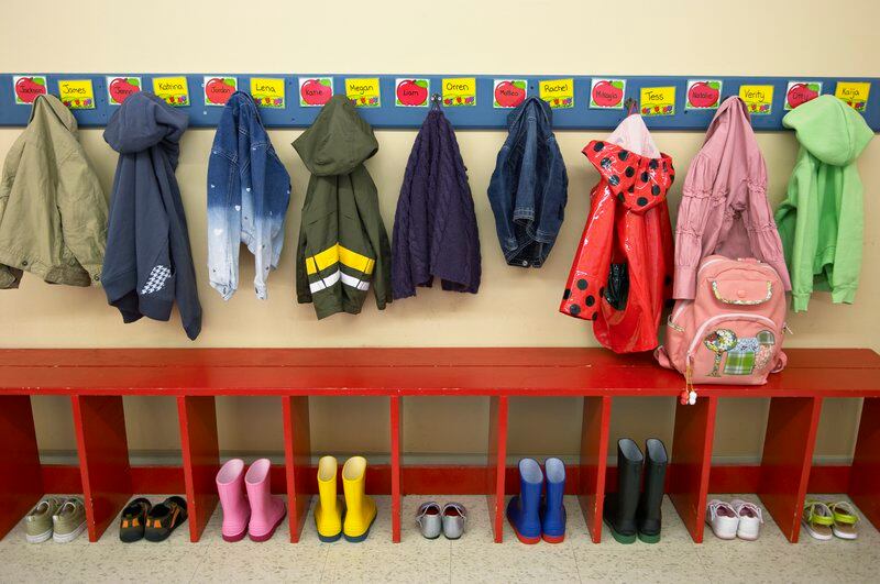 Preschoolers’ jackets and boots or shoes are lined up in their cubbies.