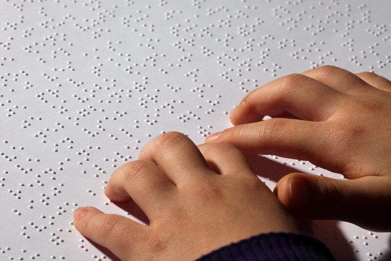 Child reads Braille text