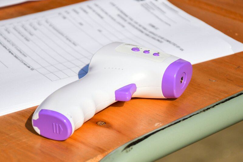 A temperature screening gun sits on a desk.