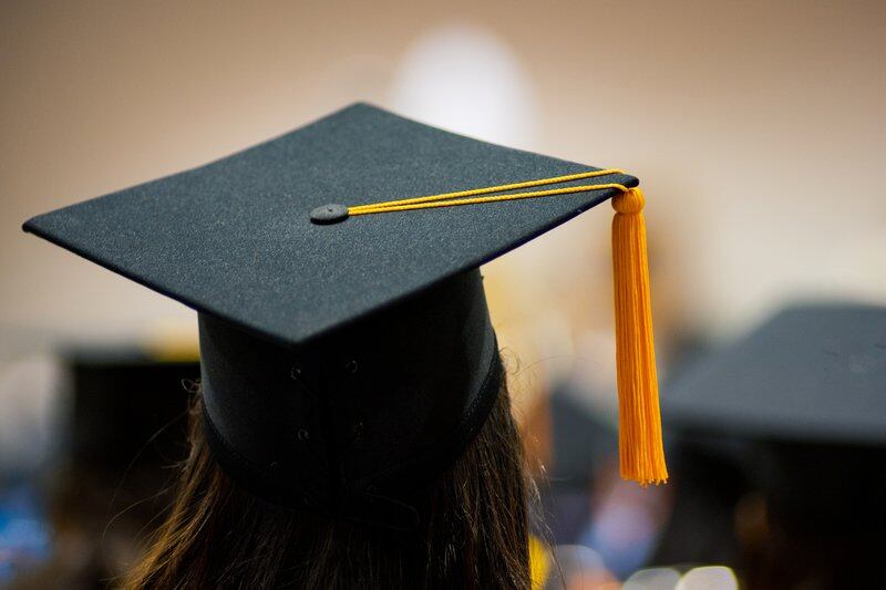 The back of the head of a woman wearing a mortarboard with a tassel hanging off the right side.