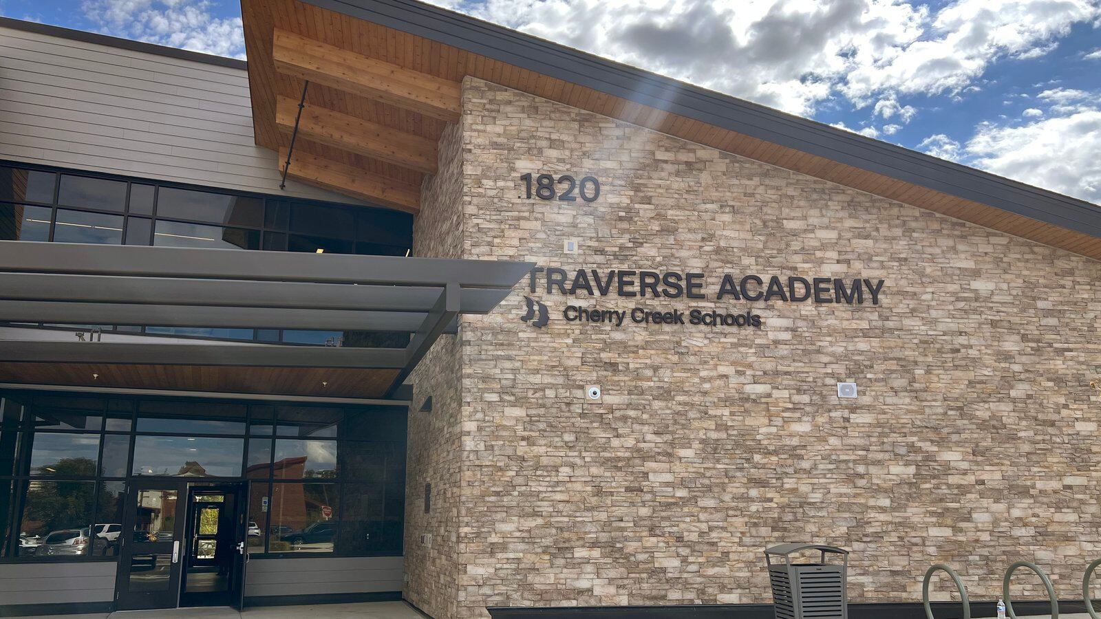 The exterior and entrance to a building with a brown brick face, marked “Traverse Academy”