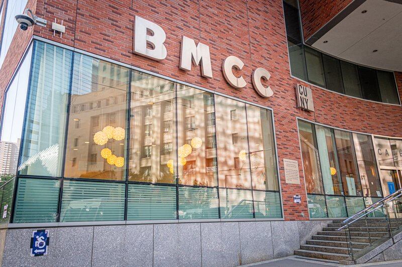 The front of a brick building that reads “BMCC” with windows underneath.