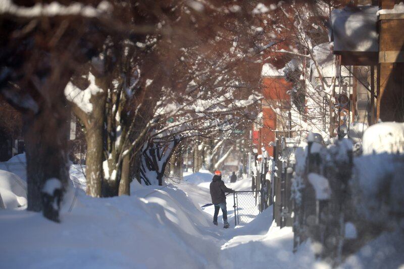 A person shovels snow from a sidewalk on February 16, 2021 in Chicago, Illinois.