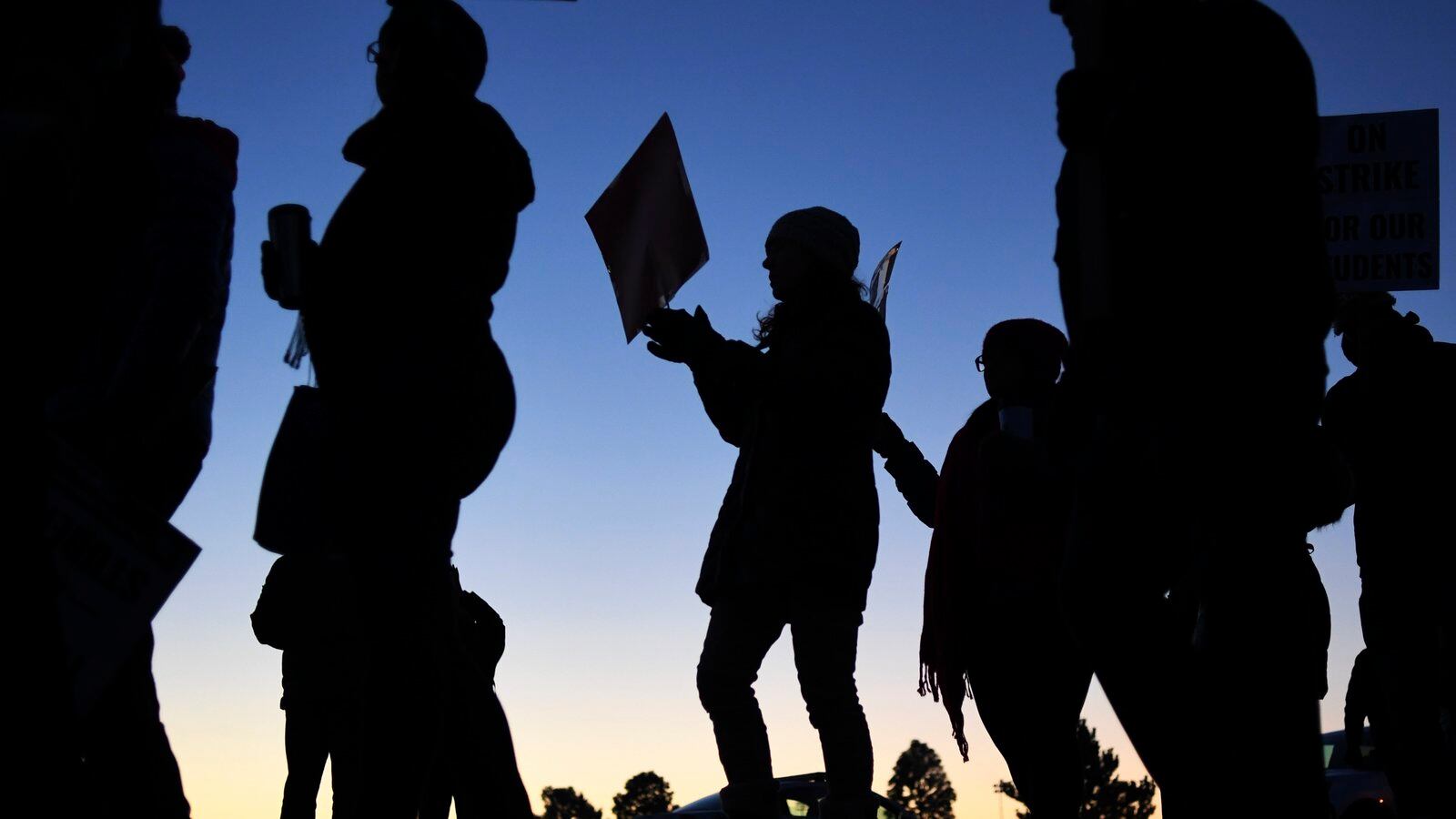 A silhouette of Denver teachers walking the picket line during the 2019 teachers strike.