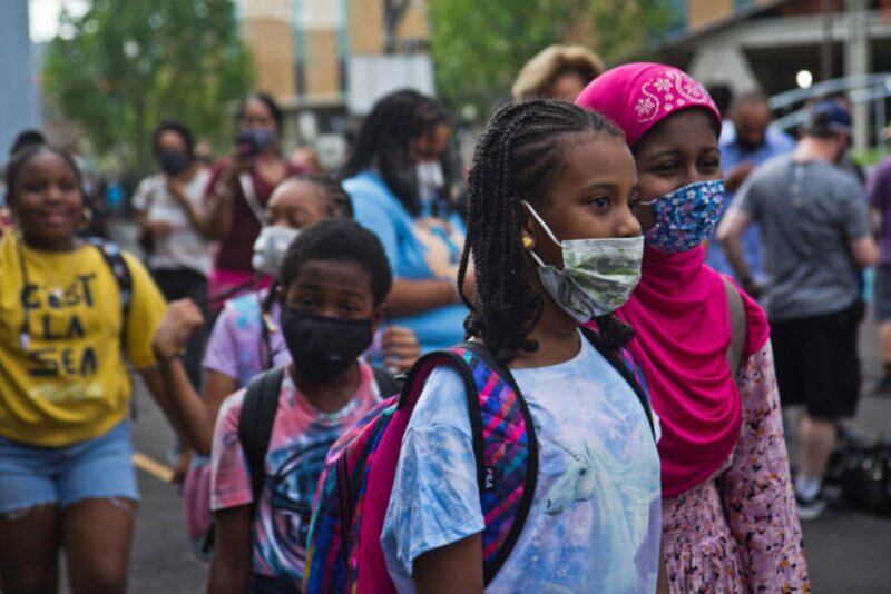 Philadelphia students, wearing protective masks, arrive for the first day of classes.
