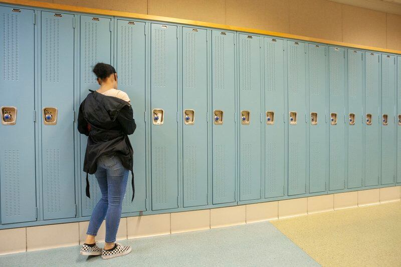 A student at her locker in a hallway at North-Grand High School in Chicago. Photo by Stacey Rupolo / Chalkbeat —May, 2019 photo—