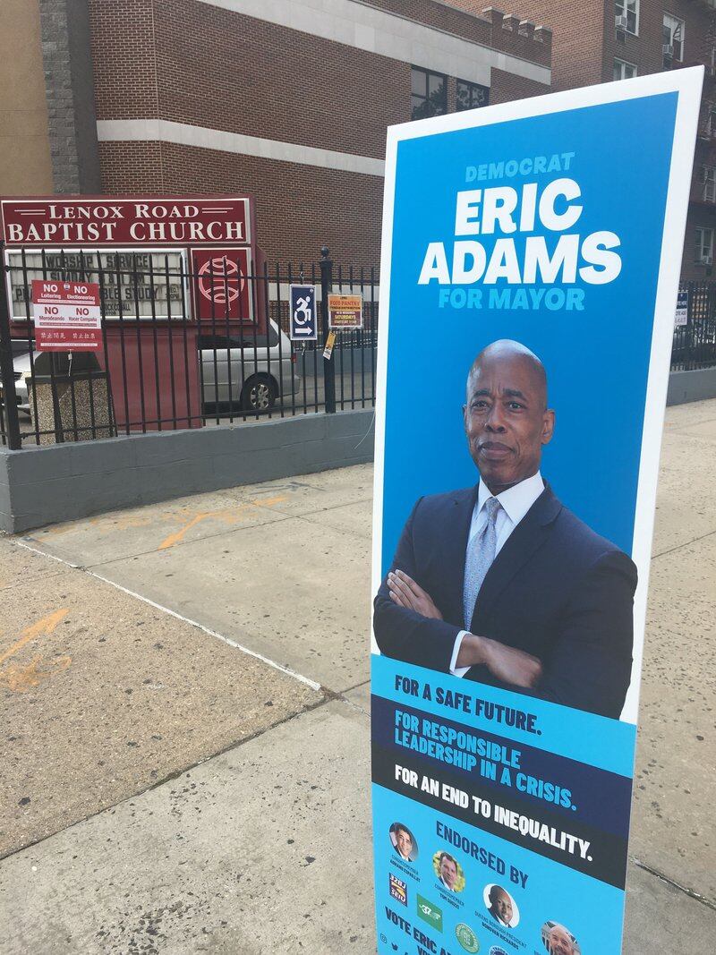 Eric Adams led the crowded field of Democratic mayoral hopefuls as of Tuesday night. A sign for the candidate on the street in front of a Brooklyn polling site.