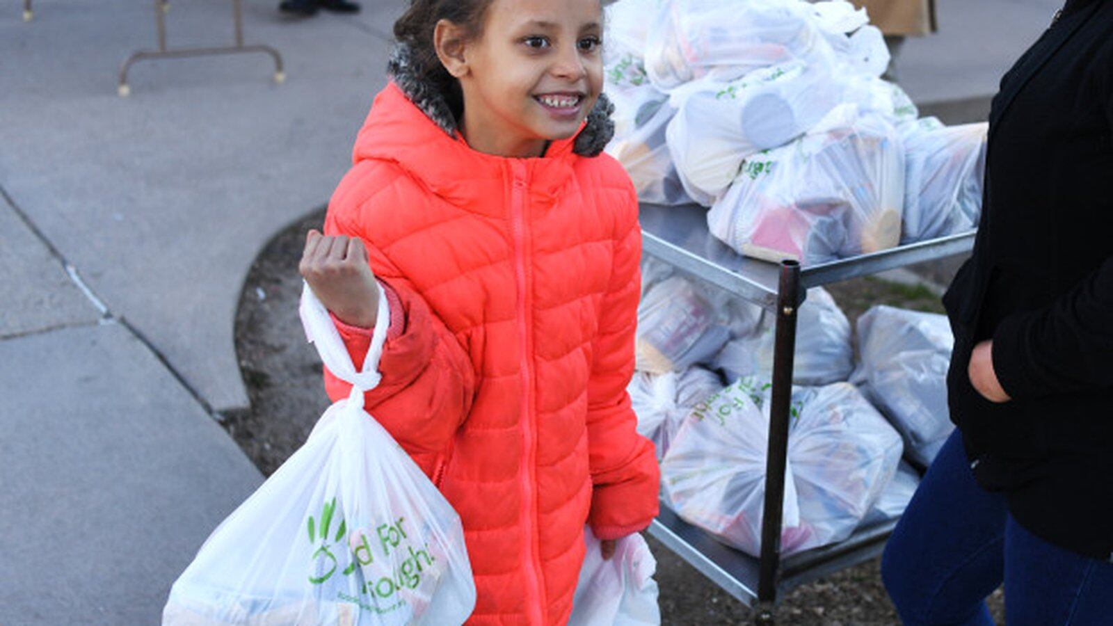 Da’vida Jones, 7, picks up a free meal and some extra food given out at Cowell Elementary on March 16, 2020 in Denver, Colorado.