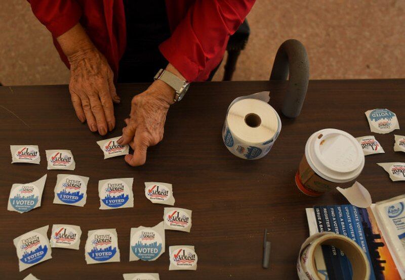 An election judge sets out voting stickers on a table.