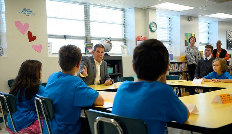 Tennessee Governor Bill Lee speaks with students wearing blue shirts.