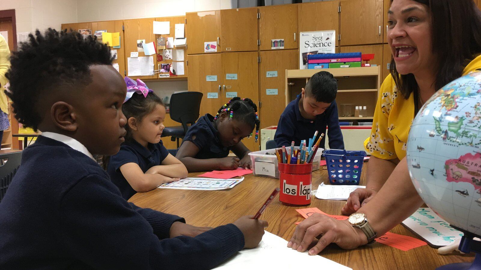 Pre-K teacher Maria Rodriguez sounds out words in Spanish to help 5-year-old Joshua Robinson with a writing exercise. Global Preparatory Academy in Indianapolis has a new bilingual prekindergarten classroom.