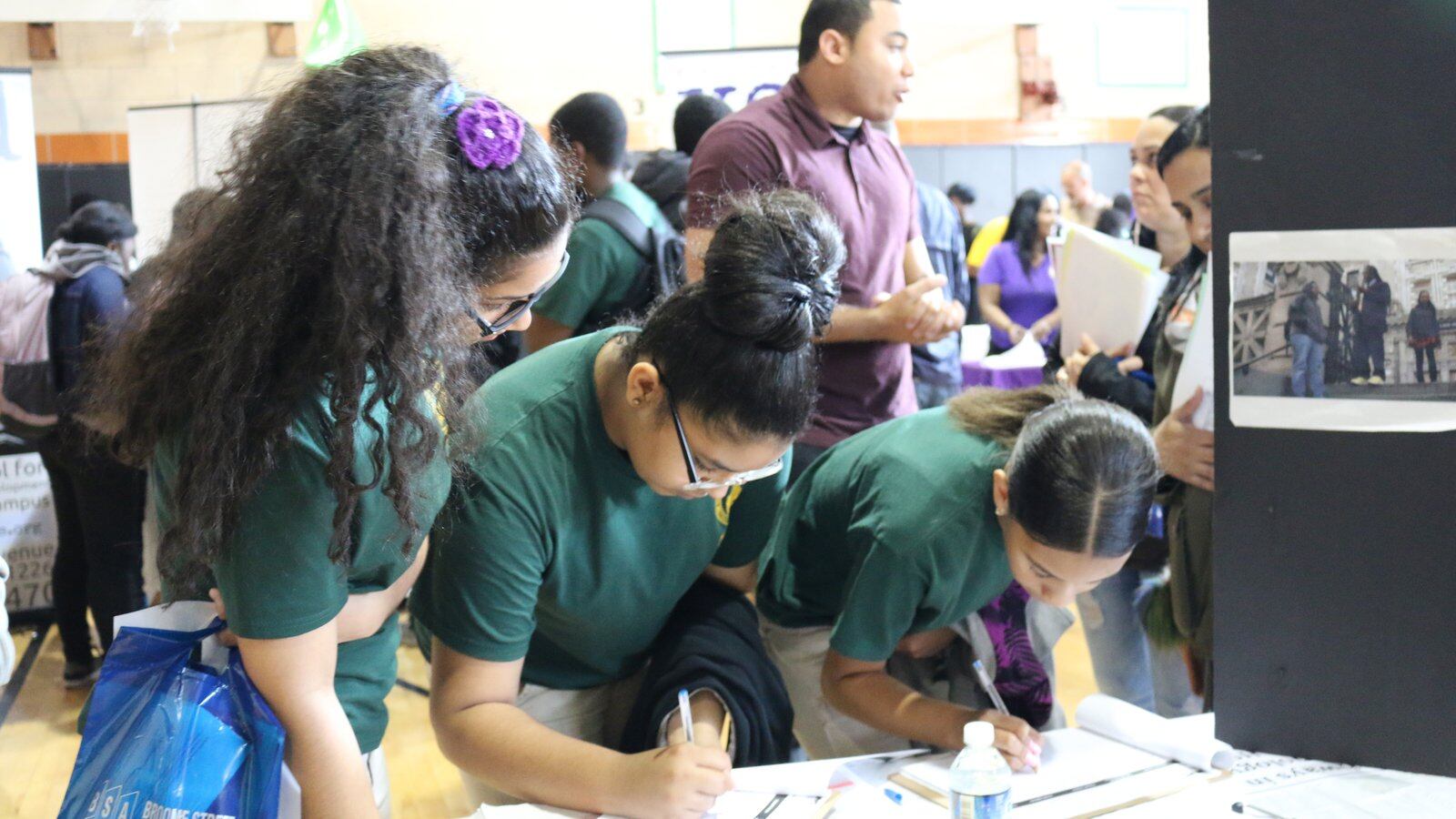 Middle school students write their names down at a high school fair in Brooklyn in 2016.