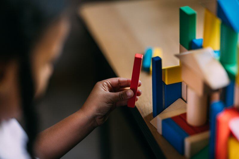 A close up of a small child playing with blocks