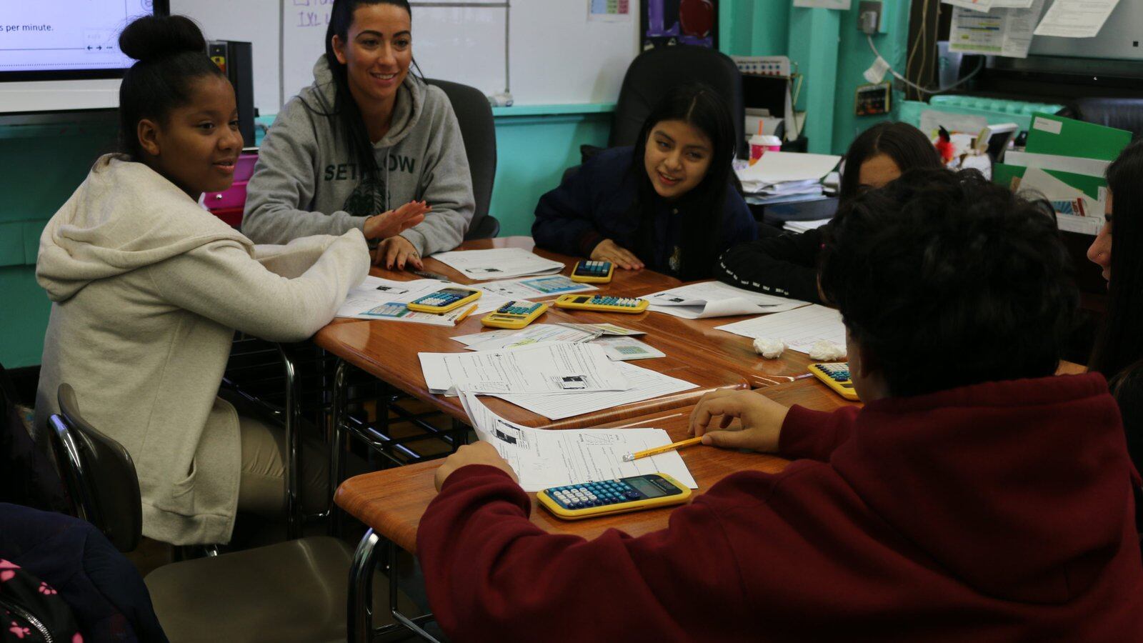 An eighth-grade math teacher discusses a problem with students at I.S. 96 and encourages a student who is learning English as a new language to explain his answer.  Roughly half of his peers are also learning the language.