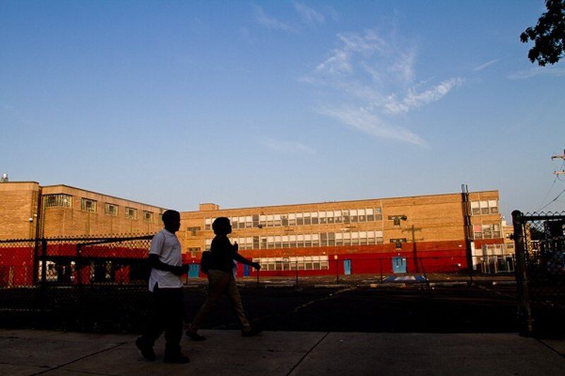 Two students walk by a Philadelphia school building.