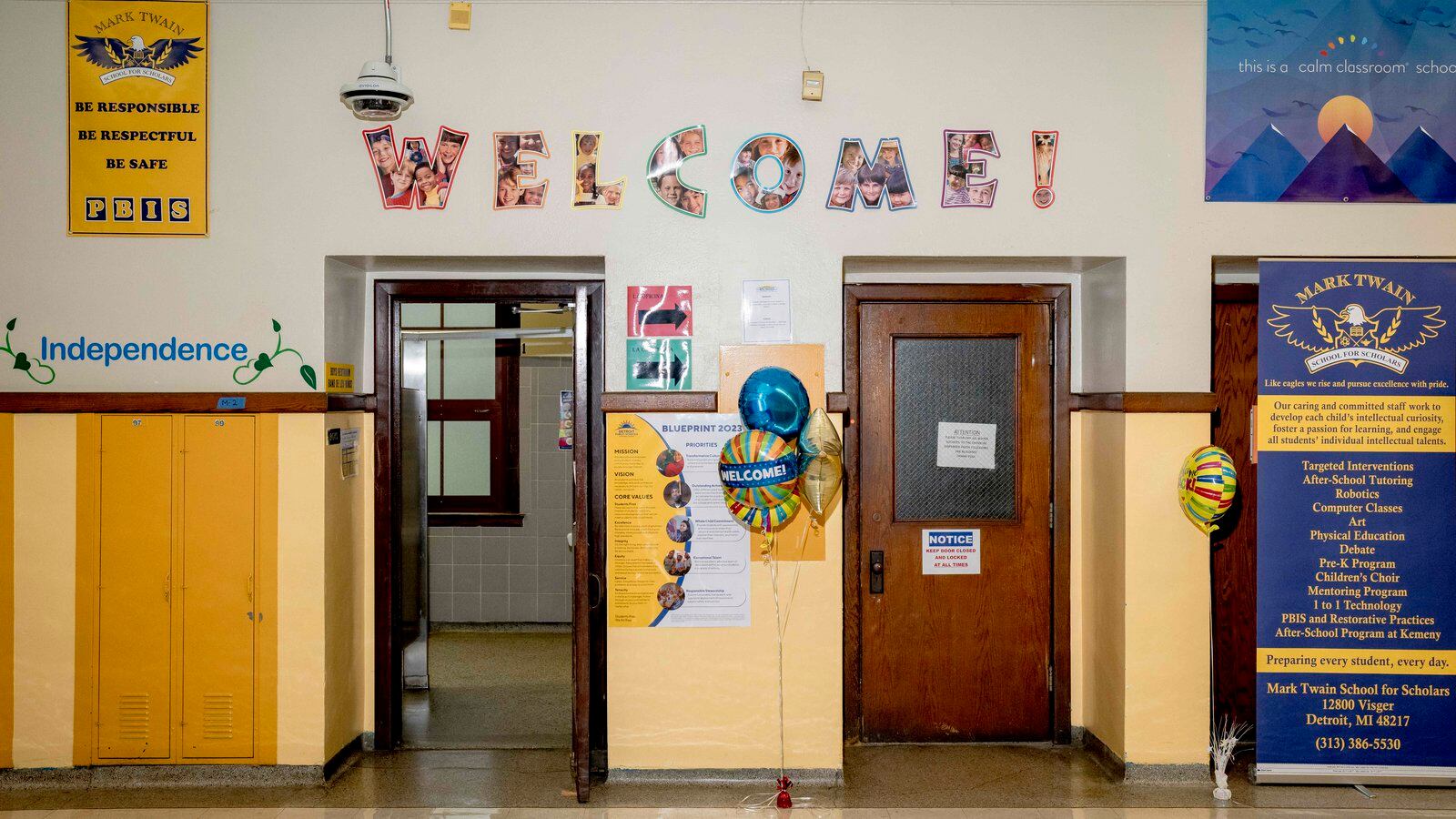 A school hallway with a welcome sign hanging up on the wall