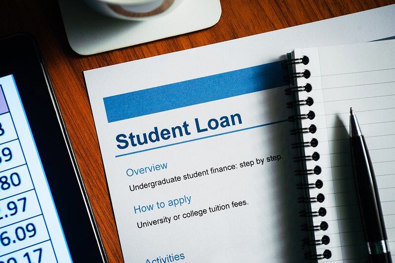 Student loan document on a desk with a pen and pad of paper.