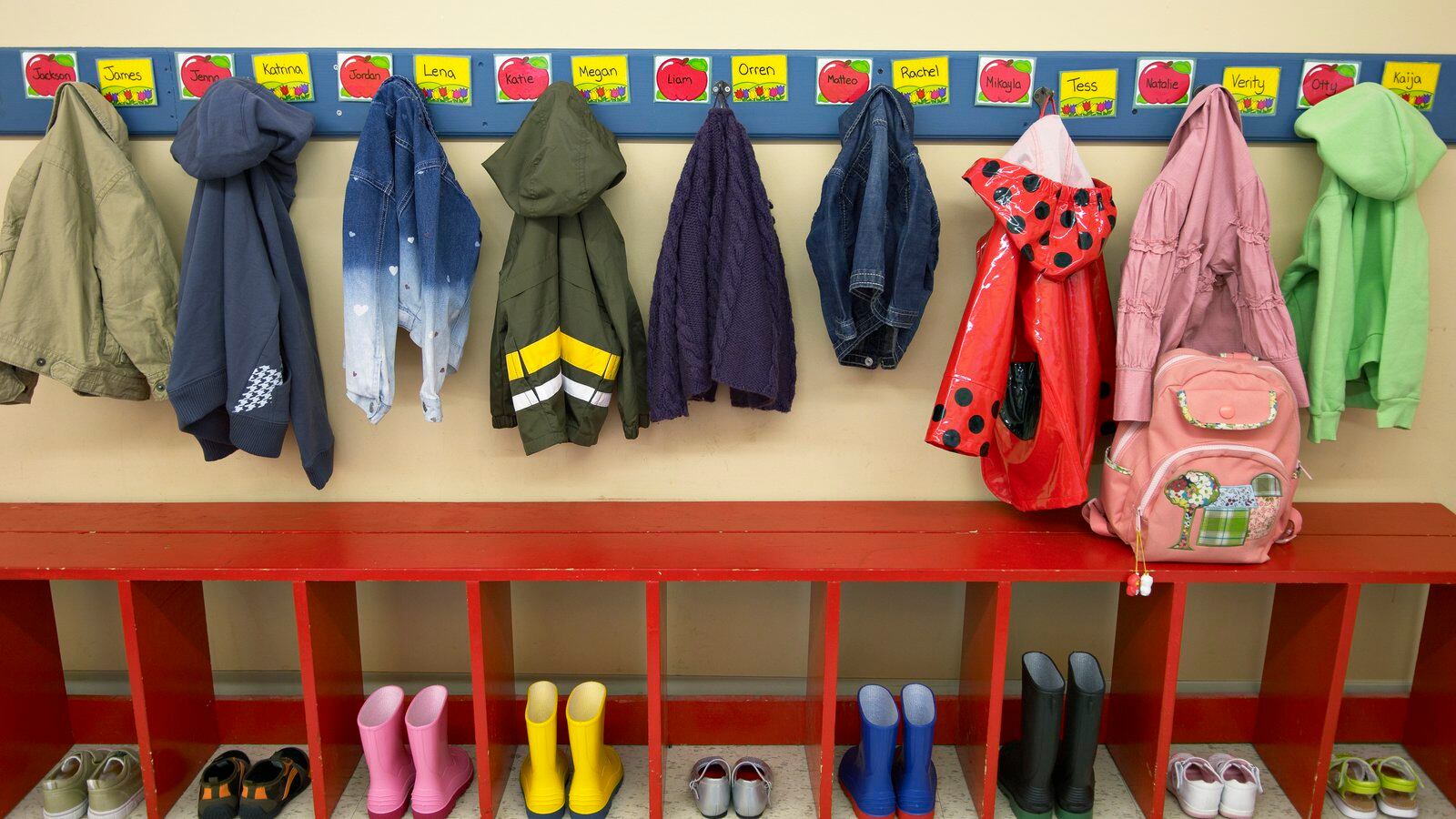 Preschoolers’ jackets and boots or shoes are lined up in their cubbies.