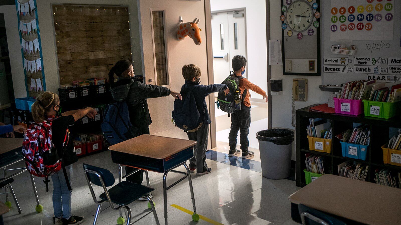 A kindergarten class socially distances while preparing to leave their classroom at Stark Elementary School on October 21, 2020 in Stamford, Connecticut. Stamford Public Schools is continuing the fall semester with a hybrid model of in-class and distance learning, occasionally quarantining individual classes when a student or faculty member tests positive for COVID-19. (Photo by John Moore/Getty Images)