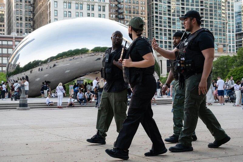 Security guards patrol Chicago’s Millennium Park at the Cloud Gate during the first night of its new unaccompanied minors restriction hours on May 19, 2022.