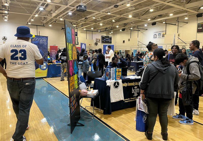 Families gather in George Westinghouse Career and Technical Education High School’s gymnasium, where local high schools have set up tables to chat with prospective students about their schools.