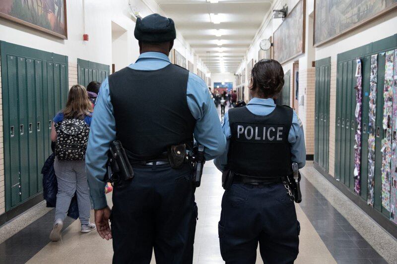 School police officers walk in the hallways of Lane Tech High School in Chicago.