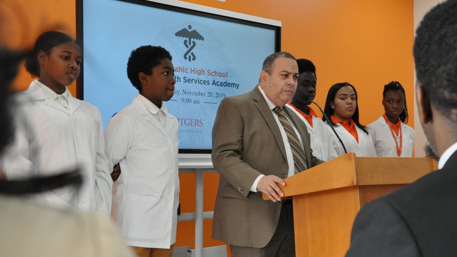 Flanked by Weequahic High School students, Newark superintendent Roger León announces a new allied health career academy.