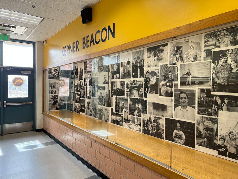 Image shows a display case full of black-and-white photos in the entry way of Kepner Beacon Middle School. The words Kepner Beacon appear above in a yellow field.