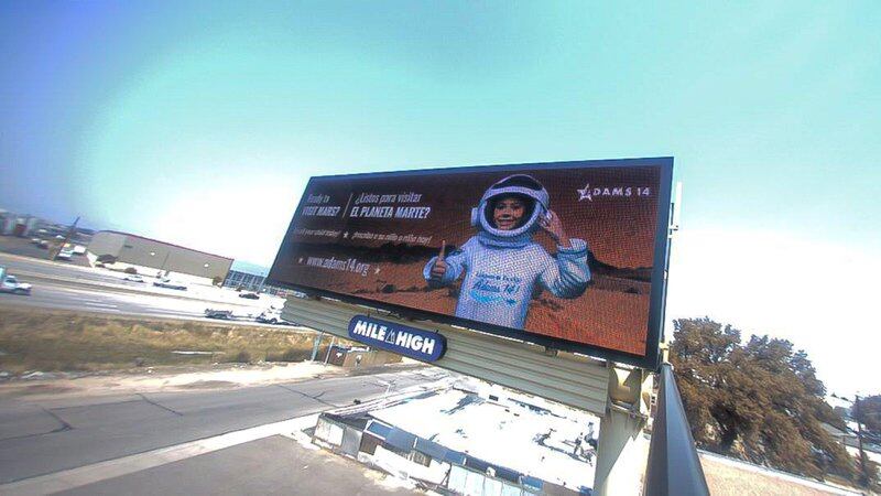 A billboard for Adams 14 School District shows a child as an astronaut with the text “Ready to visit Mars?” on the left-hand side in English and Spanish.