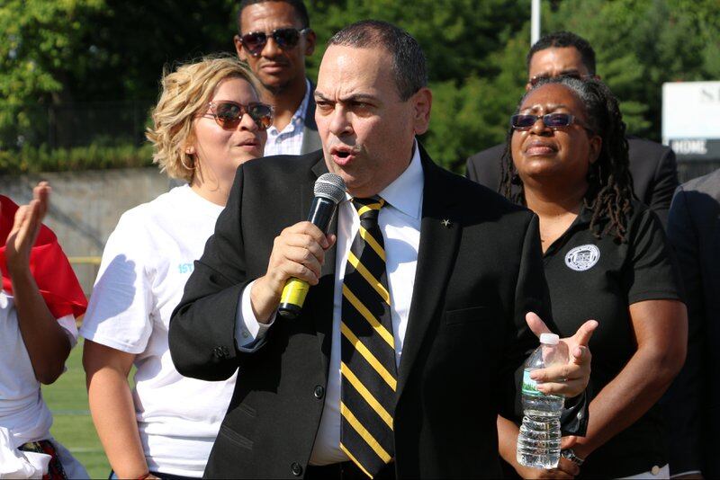 Superintendent Roger León speaking at a back-to-school event at Shabazz in 2018. Principal Naseed Gifted stands behind him, second from left.