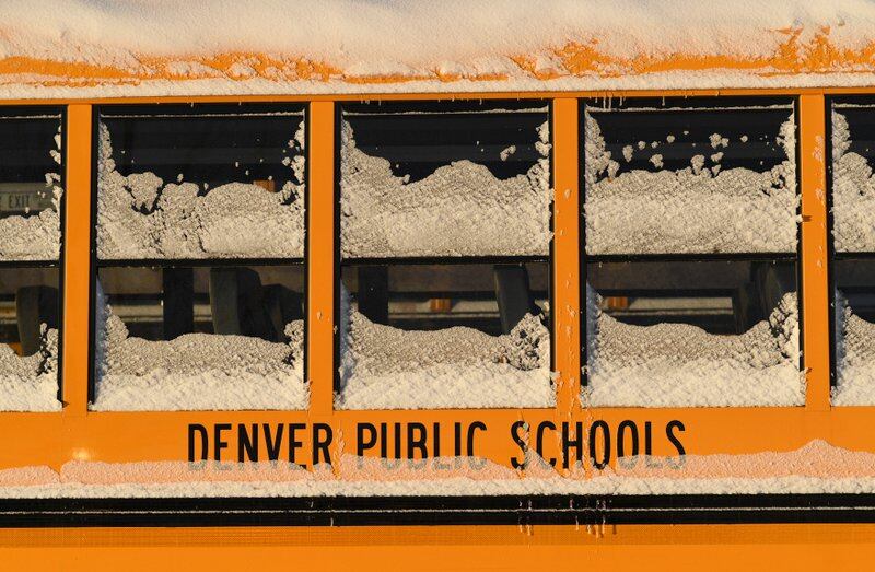 Snow and ice cake the windows of a yellow school bus