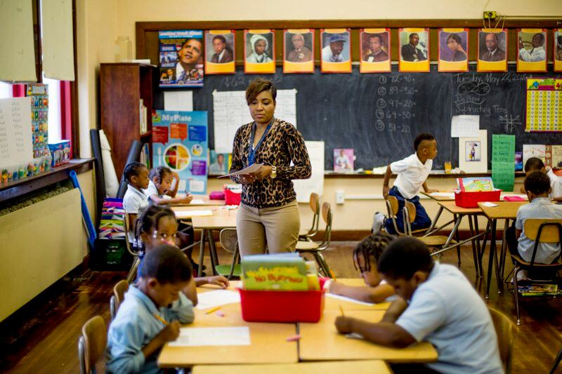 Rynell Sturkey teaches first-grade at Detroit’s Paul Robeson Malcolm X Academy. Several students work at desks around her.