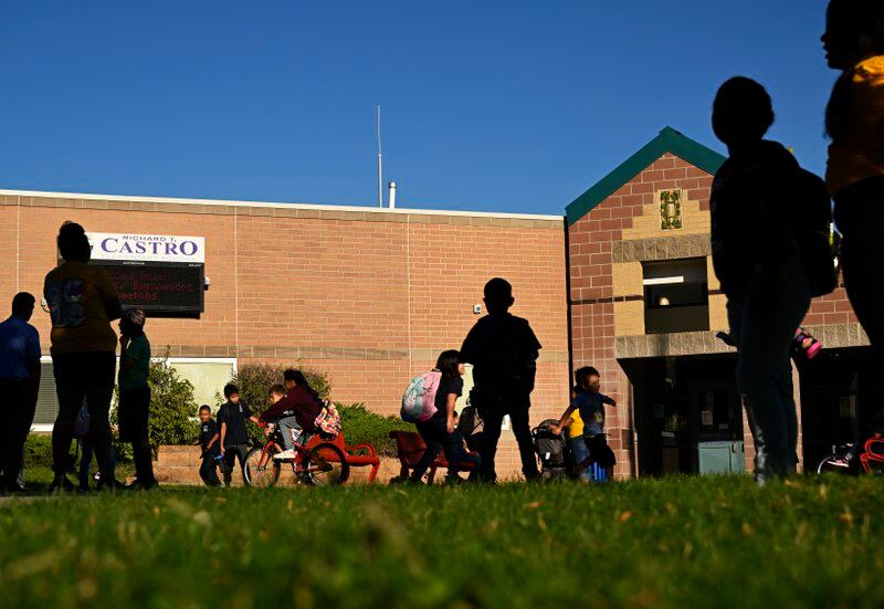 Students and parents are silhouetted as they arrive to Castro Elementary in the morning.