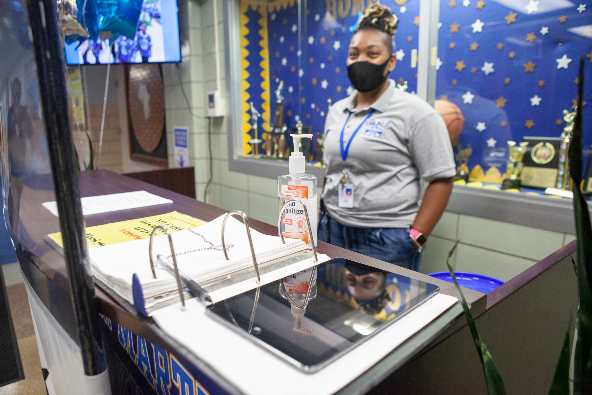 A health screening station with an ipad and hand sanitizer.
