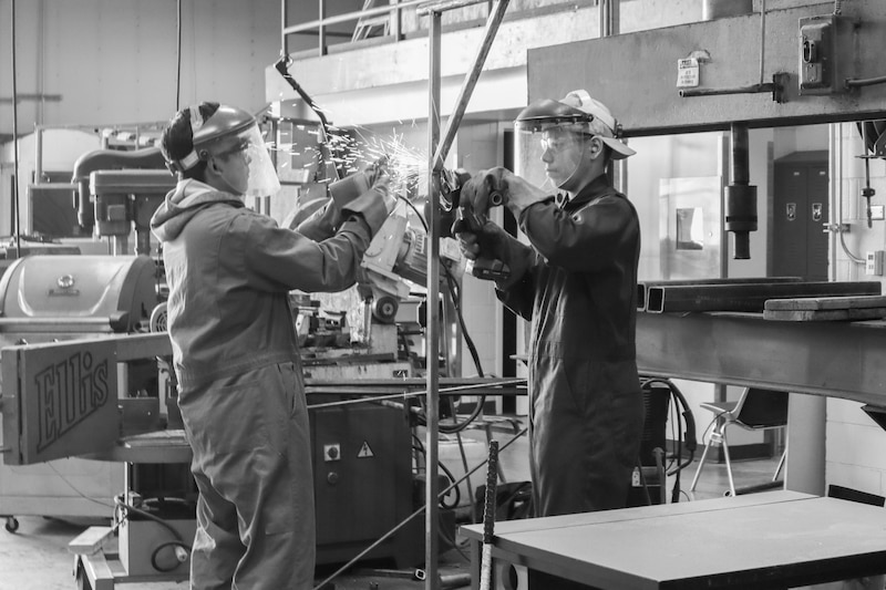 Two students with protective eye gear are at work.