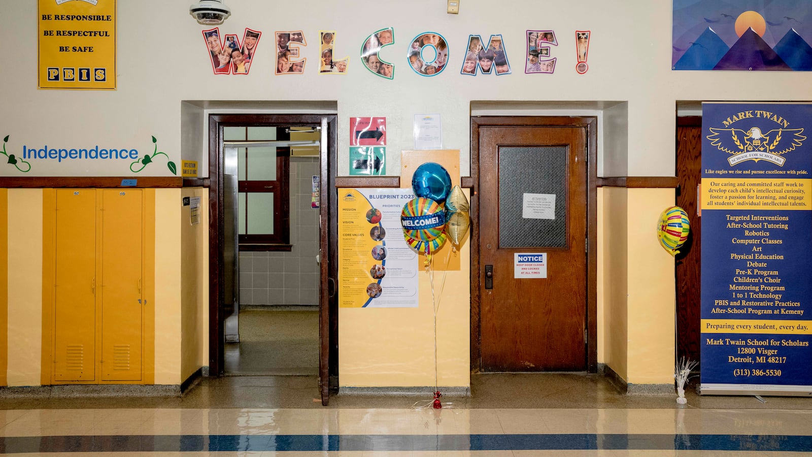 A school hallway with a welcome sign hanging up on the wall