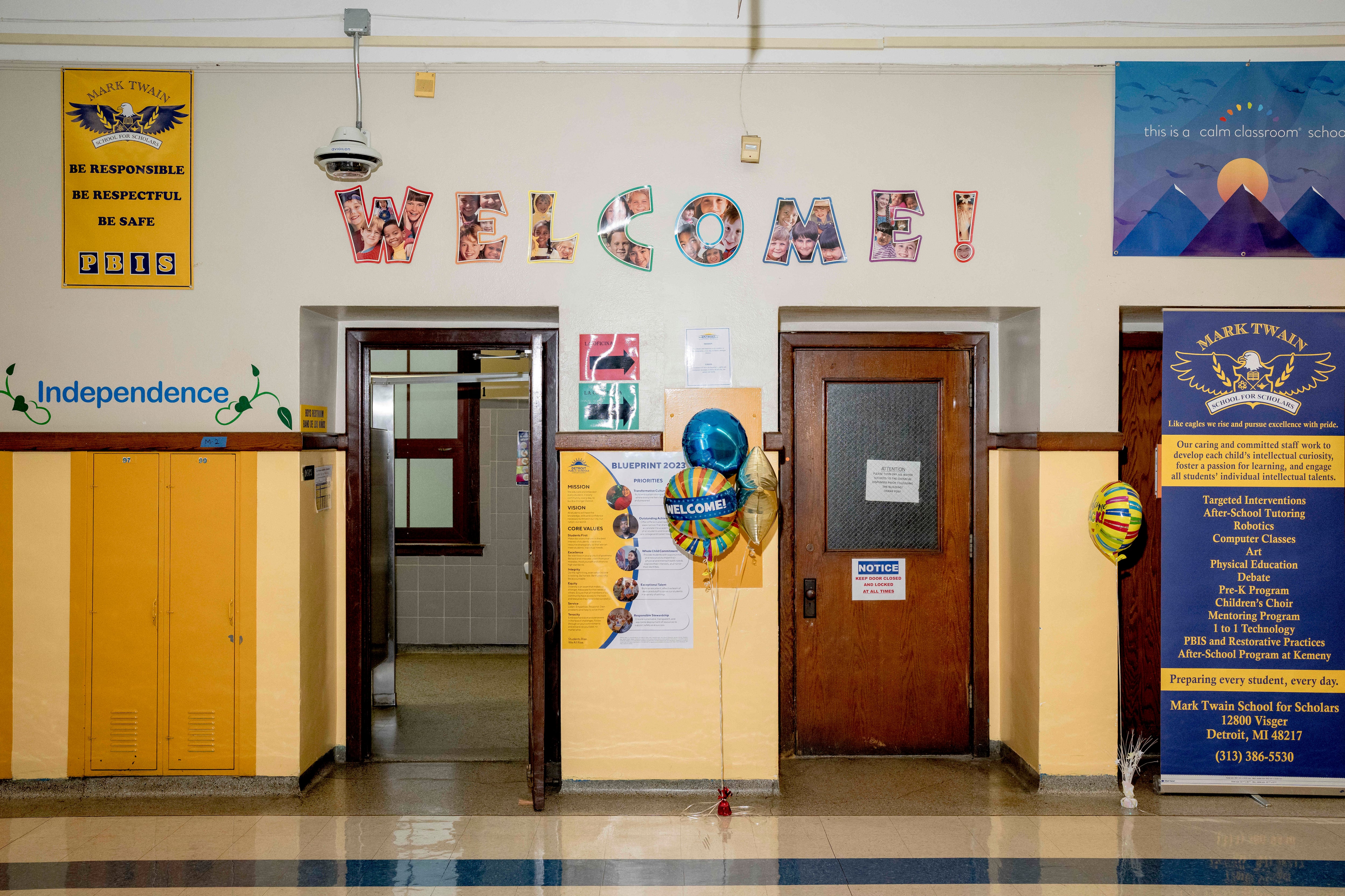 A school hallway with a welcome sign hanging up on the wall