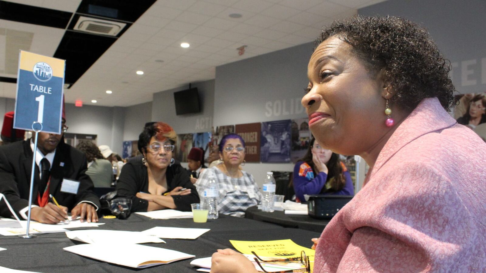 Corletta Vaughn, a candidate for Detroit school board, speaks to Detroiters at a forum Thursday evening as Nita Redmond (center) looks on. Vaughn says the district should be open to collaboration with charter schools and suburban districts.