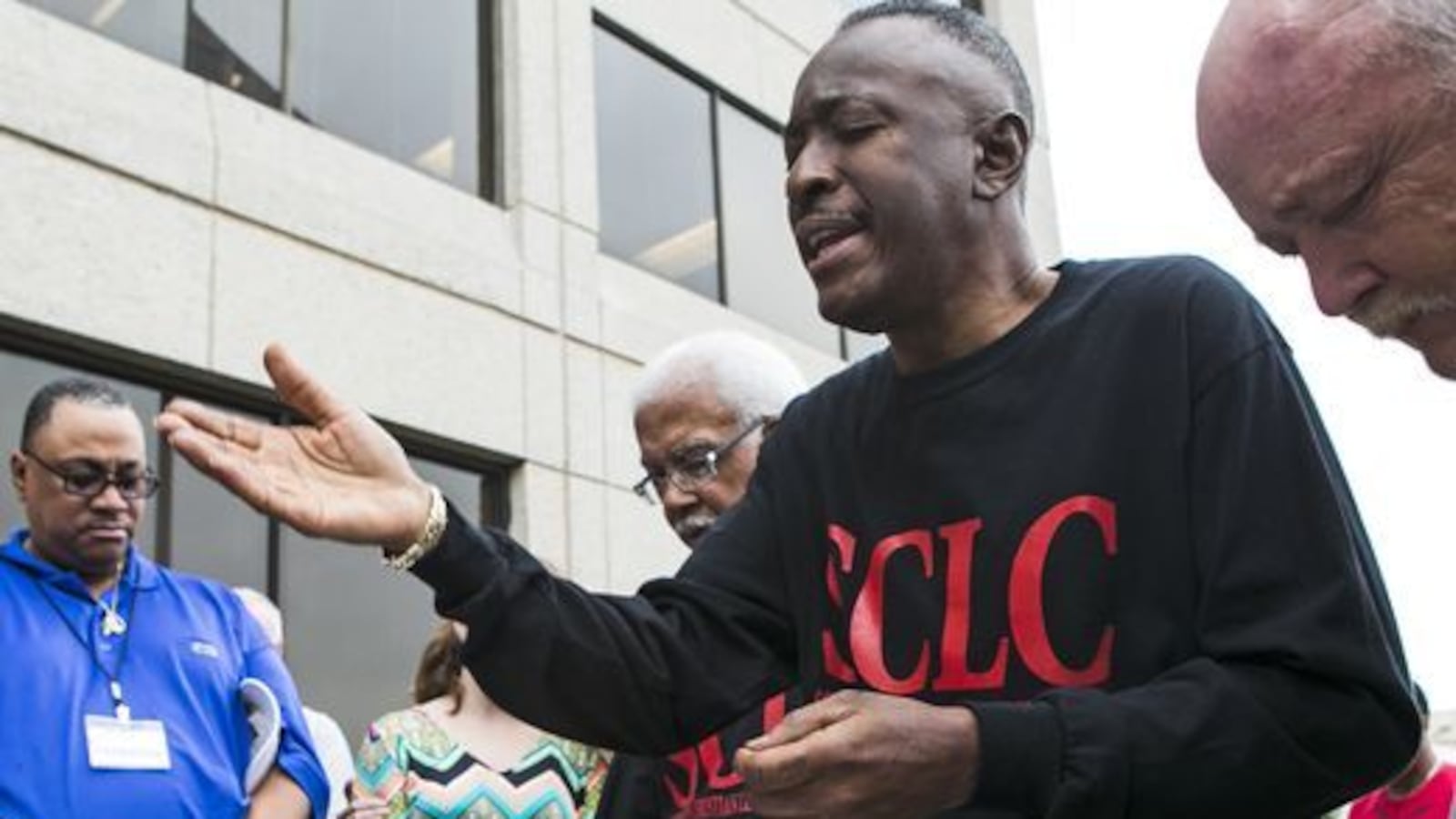 Pastor Dwight Montgomery, president of the Memphis chapter of the Southern Christian Leadership Conference, prays with Kellogg workers who filed race-based discrimination complaints in 2014. Montgomery died on Sept. 13 at the age of 67.