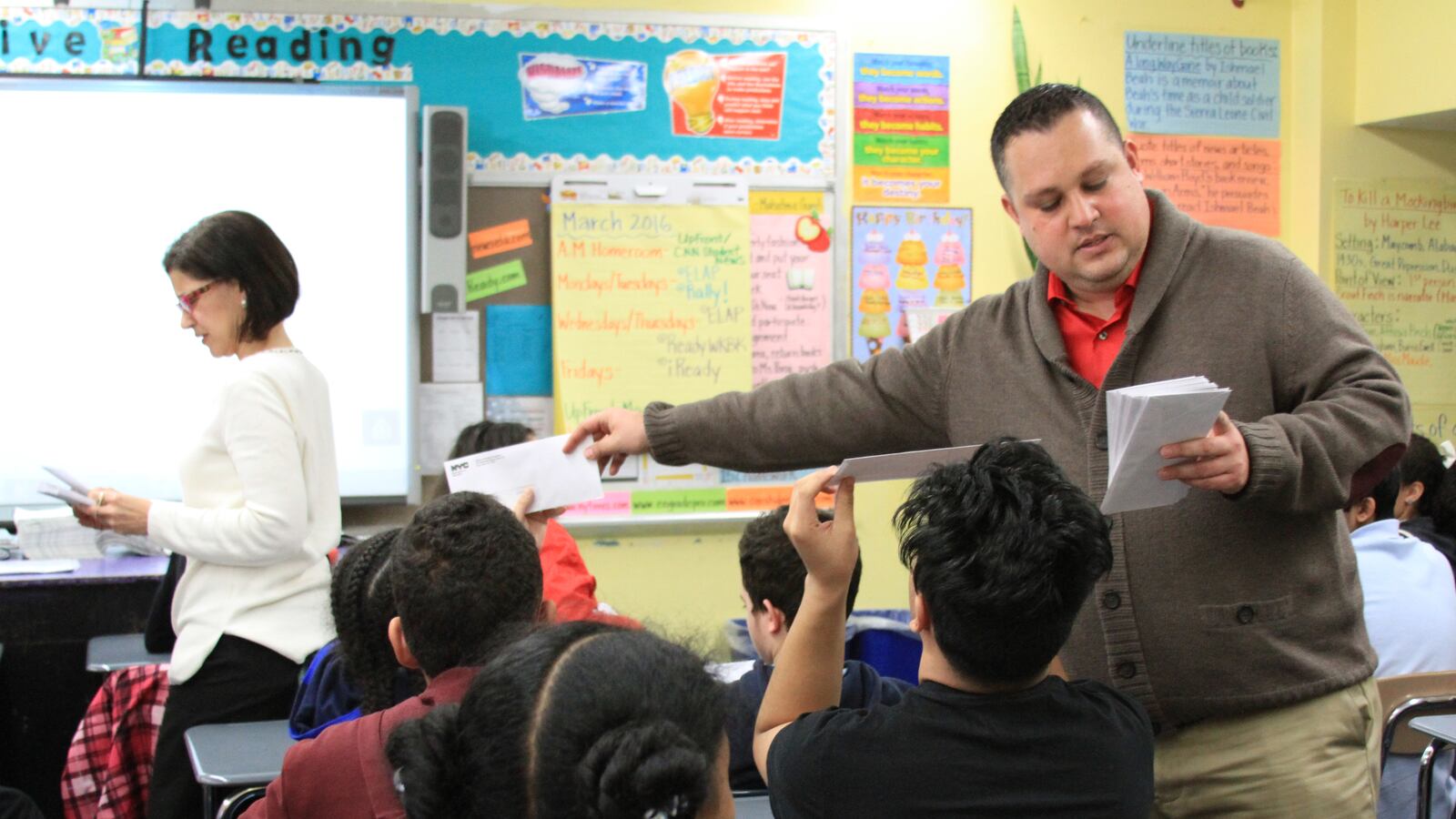 M.S. 244 Principal Eduardo Mora and guidance counselor Nancy Acosta handed out high school offer letters to eighth-graders on Friday.