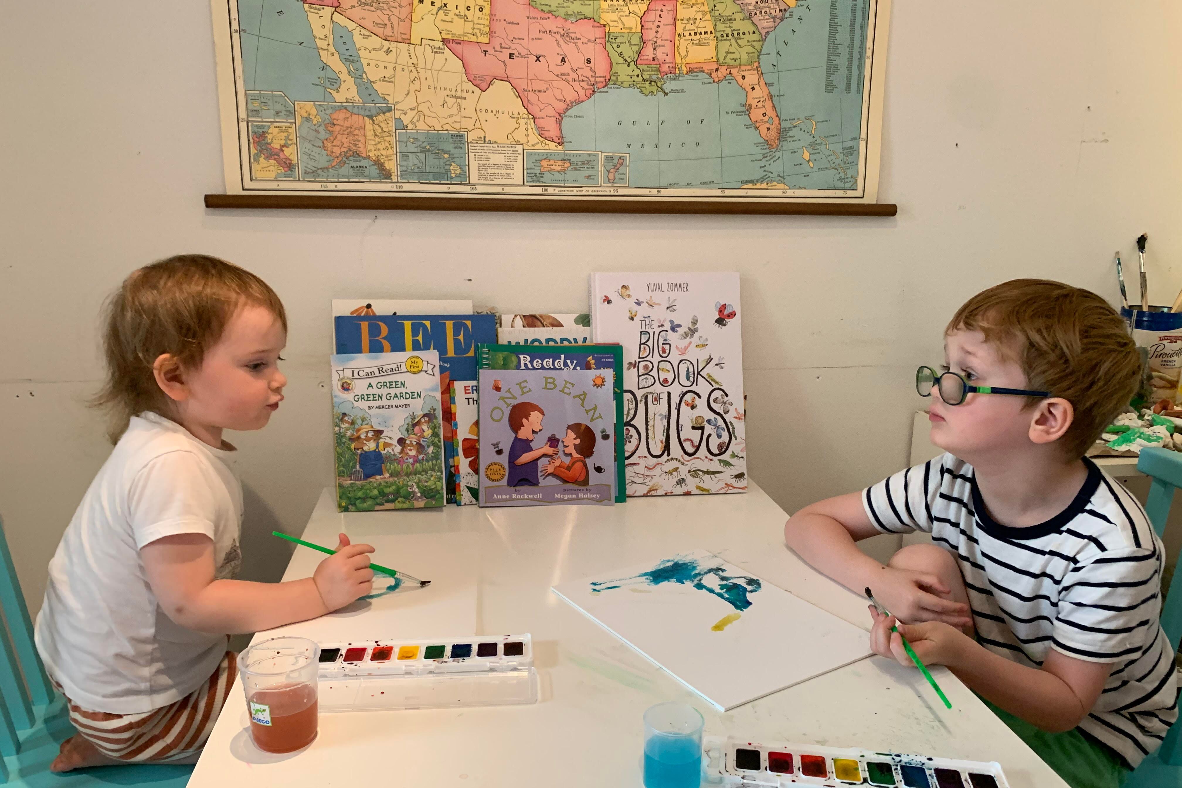 Five-year-old Logan Walker, right, and his 3-year-old sister, Sojourner, paint at a table in a makeshift classroom at their Boulder home. 