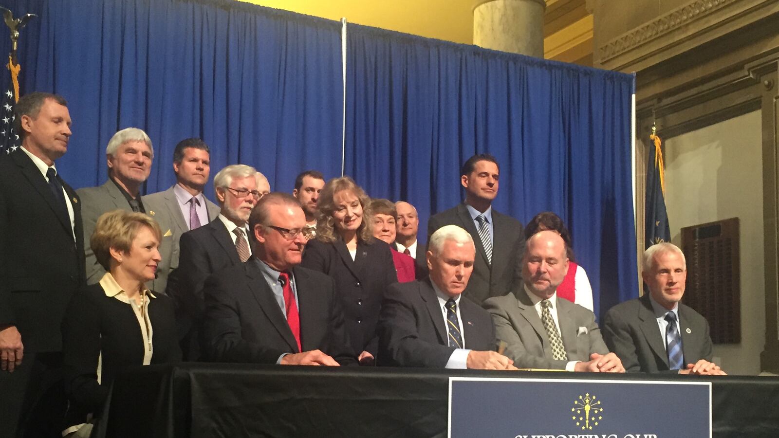 Gov. Mike Pence signs Senate Bill 200 and House Bill 1003, both with the goal to ease the consequences of ISTEP score drops on schools and teachers, into law.