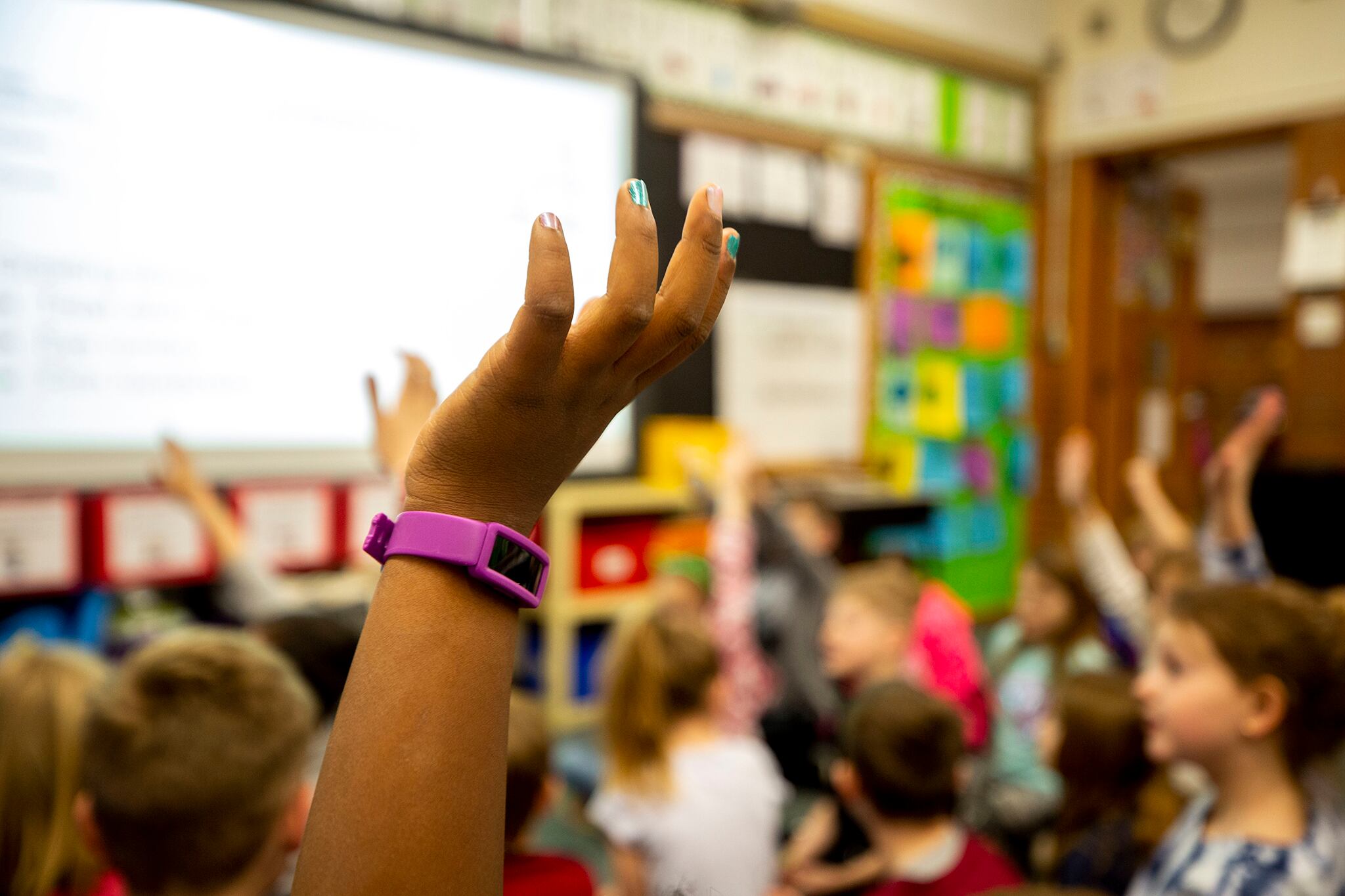 A second-grade student raises their hand at Denver’s Carson Elementary.