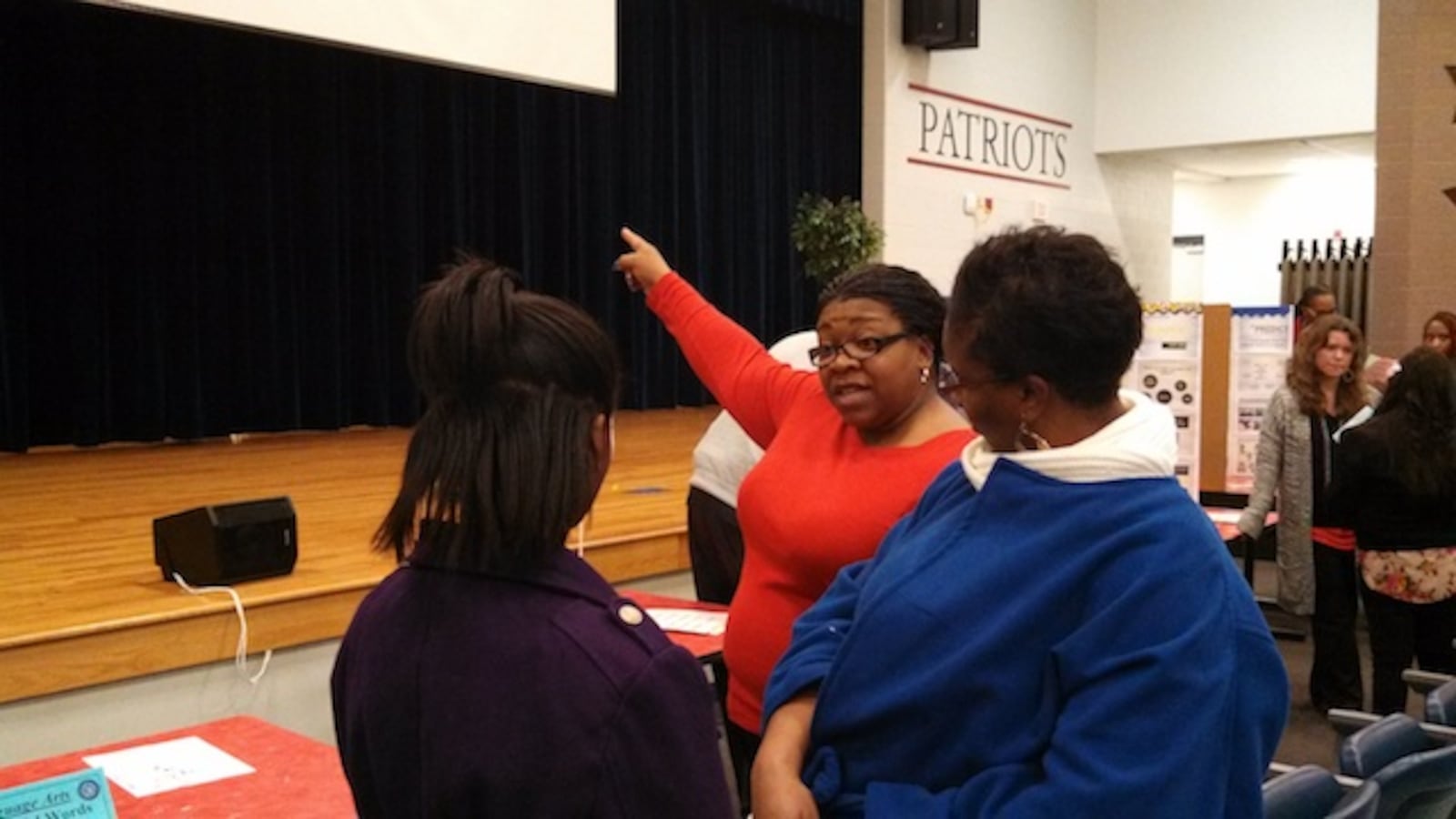 Colonial MIddle language arts teacher Patricia Hervey talks to student Ayante Williams and her mother, Sharon Kuykendall, about creative arts high school options.