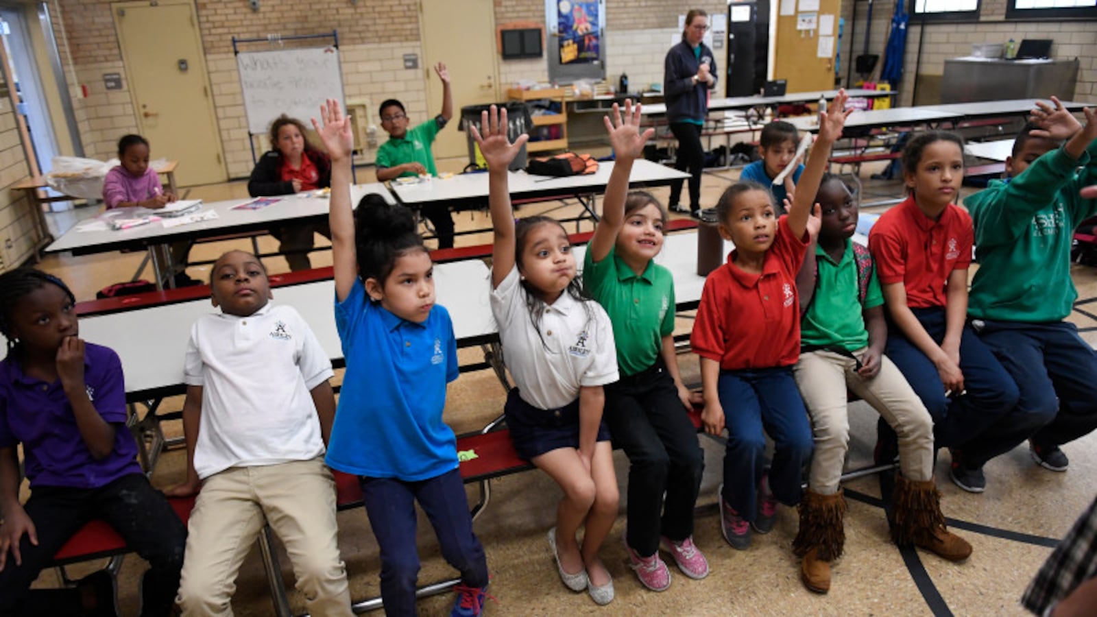Aliyah Biggs, 6, second from left and Ashli Ramos-Rosales, 8, raise their hands to take part in an after-school talent show at Ashley Elementary in Denver.