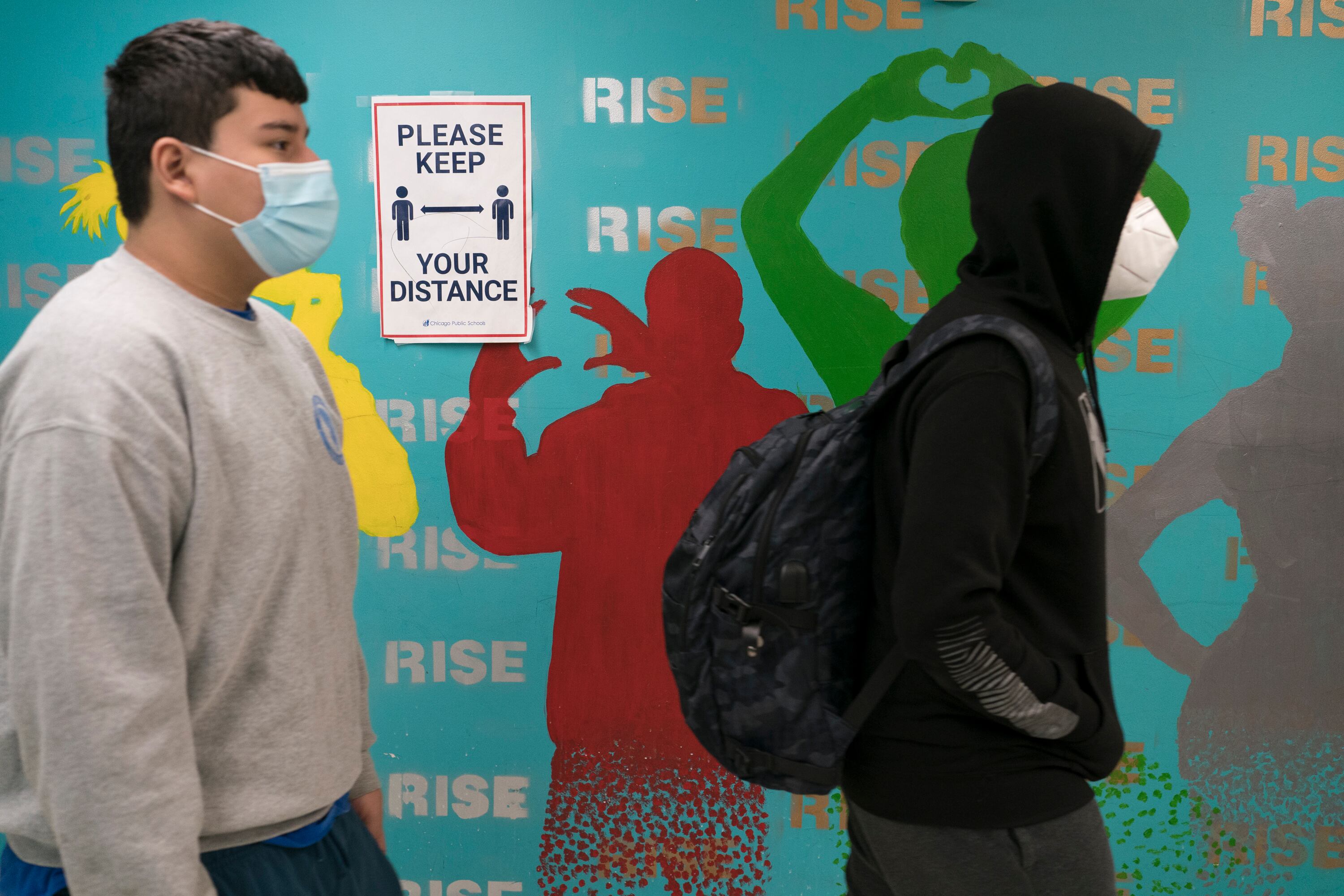 Two students wearing masks walk in a highway at a high school in Chicago.