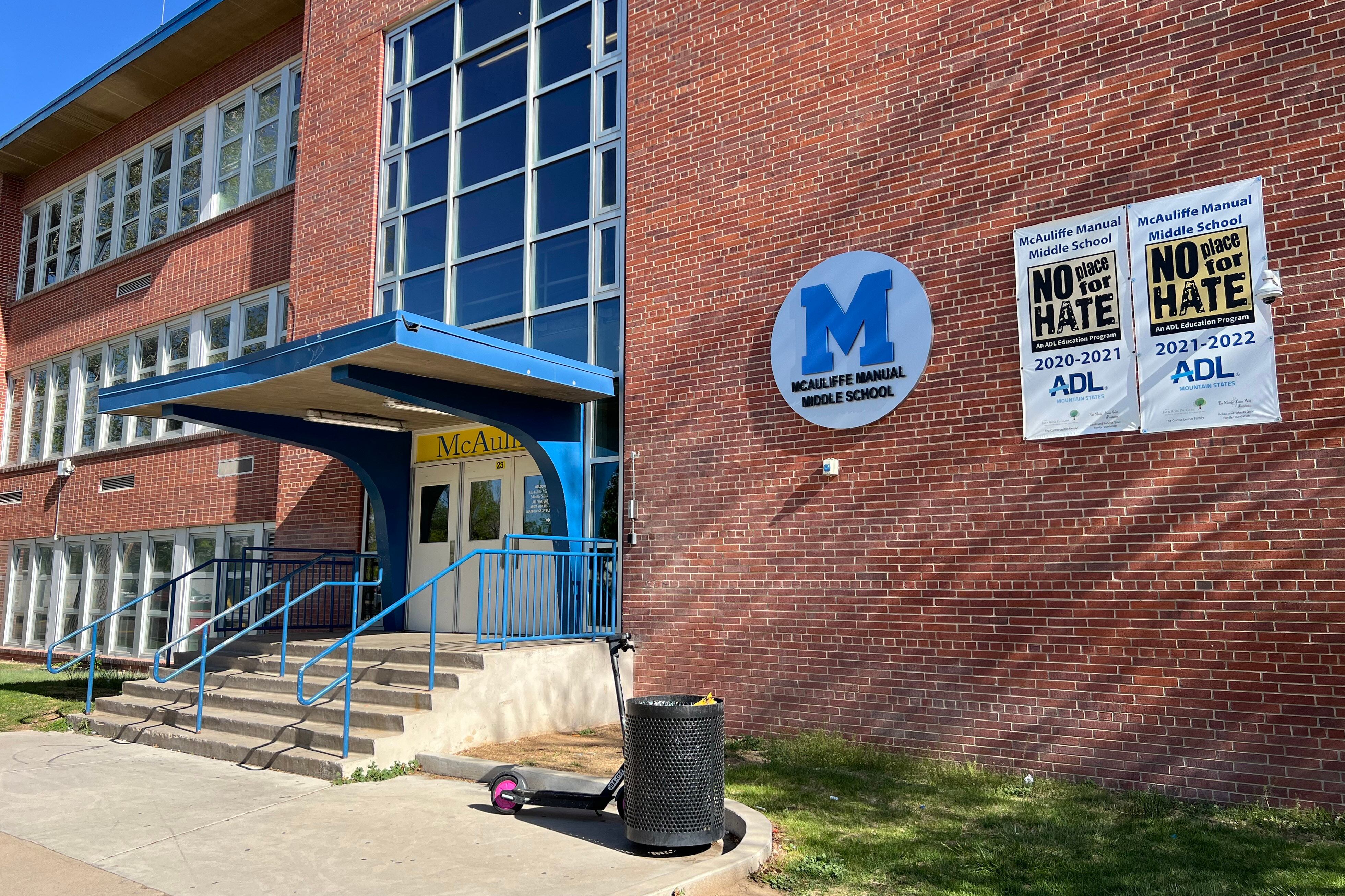 The front entrance to a large, red brick school building.