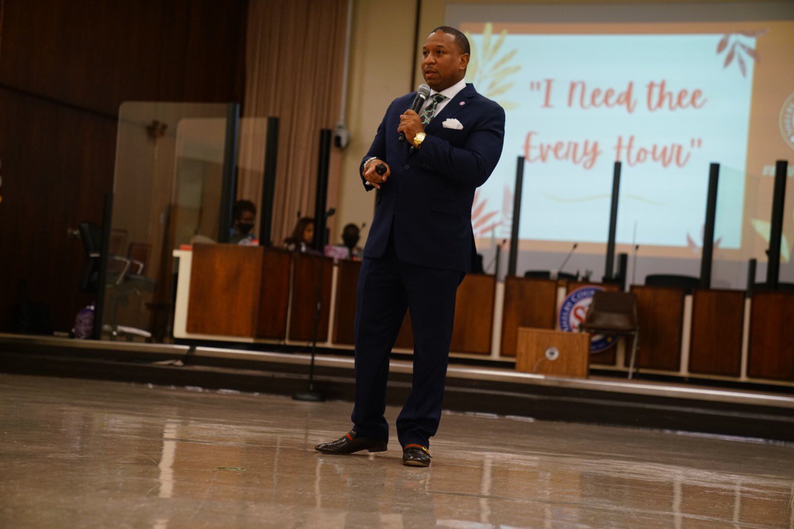 Shelby County Schools Superintendent Joris Ray stands in front of a projector that says “I need thee every hour.”